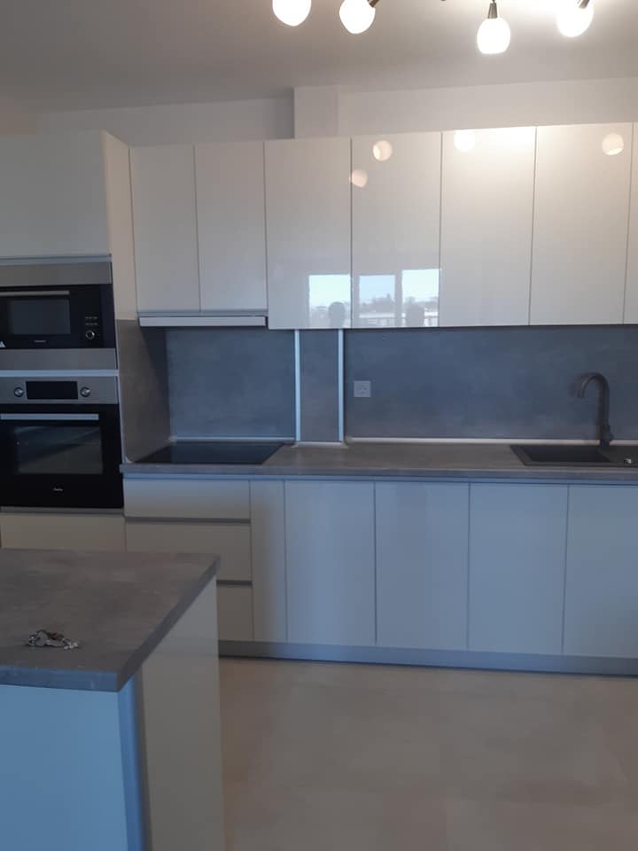 U-образна кухня с висок гланц и бетонна визия снимка 2